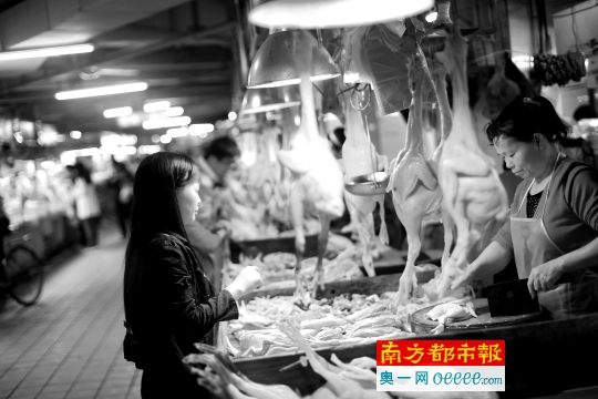 昨日,天河区一肉菜市场,市民在买光鸡。从4月1日起,广州将有1/5区域、约600家禽类档口限制活禽交易。南都记者 林宏贤 摄