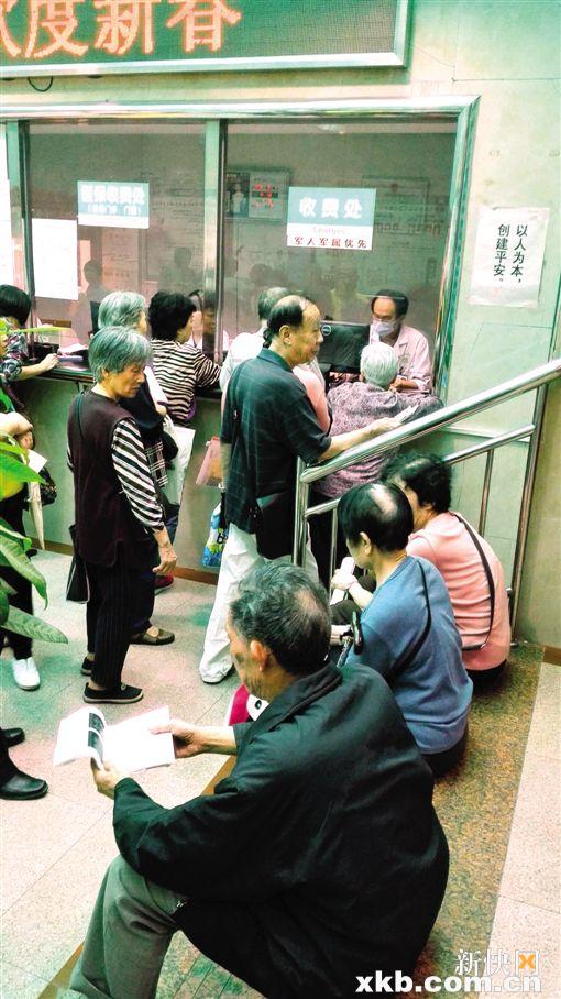 ■一些老人排队到窗口被告知医保卡不能刷后,失望地席地而坐,等待系统恢复。黎秋玲/摄