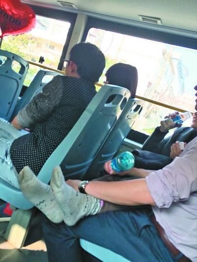 女子脱去鞋袜,双腿放在男子腿上。