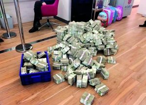 市民李先生把35万张1元零钞全倒在银行大堂地面上。 信息时报记者 郭柯堂 摄