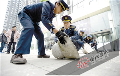 10日,渝北区市政综合执法支队龙塔大队的执法人员在紫荆路清除临街门面设置的人行道上用于占道停车的障碍物。