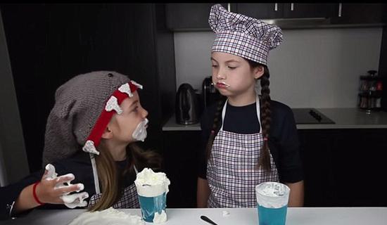 姐妹俩在视频中吃蛋糕搞得满脸都是，非常可爱。(网页截图)