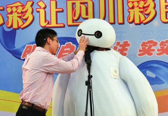 因为裹得太严实,工作人员将话筒塞进“大白”的嘴里。