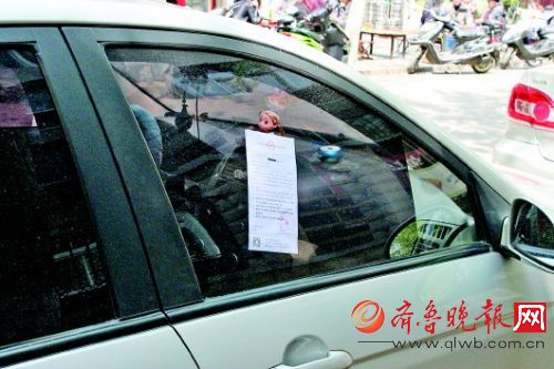 在棋盘小区，不少车辆被贴上“罚单式广告”。齐鲁晚报记者孟燕摄