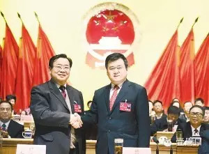 新當選的市人大常委會主任徐光與李洪民親切握手。（記者 沈湛 攝）