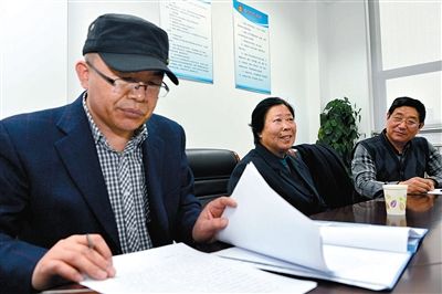 3月17日,在山东省高级人民法院,聂树斌案件代理律师李树亭(左)在查阅相关材料。 新华社记者 郭绪雷 摄