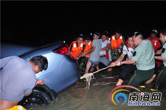 万宁消防官兵与附近村民奋力救援被困的人员和车辆