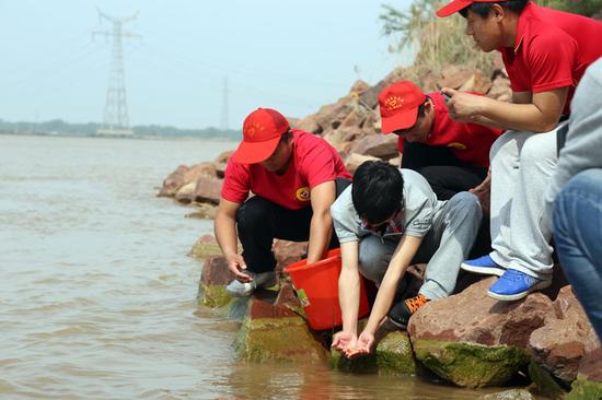 黄河交通学院大学生在黄河边投放鱼苗