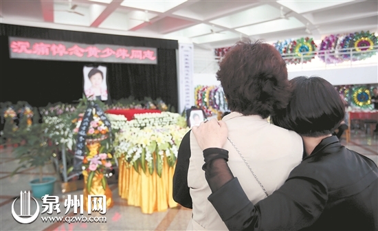 悼念大厅,两位前来吊唁的女士沉浸在悲痛中。