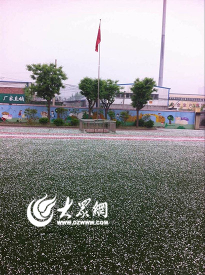 济南西部一校园内，一层冰雹将操场覆盖（网友拍摄）