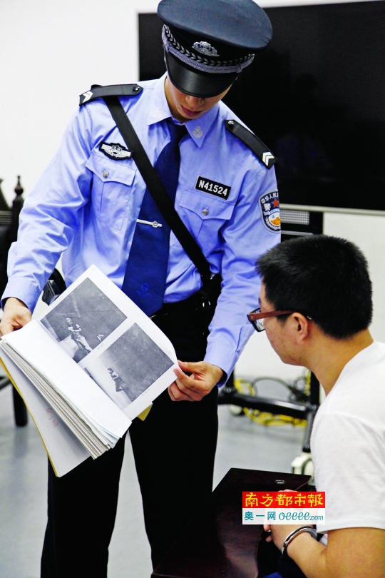 昨日,南沙法院,法警给被告人王某发看事故现场的资料。南都记者 高贵彬 摄
