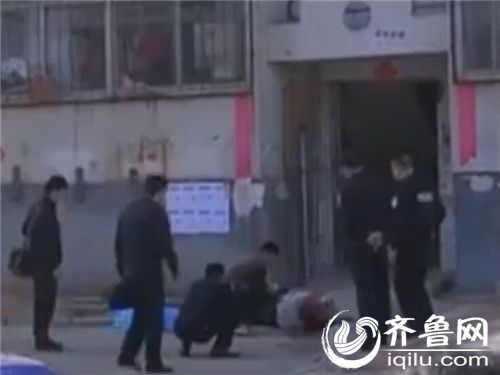 男子脸部向下趴在地上，身子周围是一大片血迹，警察在现场调查。（视频截图）