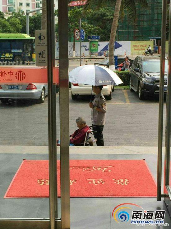 保安烈日下为老人撑伞(图片来源：网络)