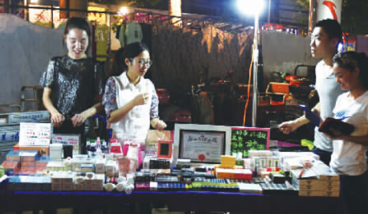 刘琦(左一)专心地向老顾客讲解着自己的产品