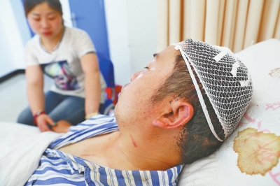 謝新永躺在病床上，愛人在身邊照顧。