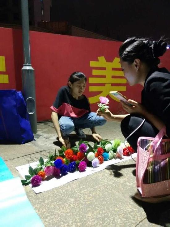 梁小群晚上在民生广场卖花。