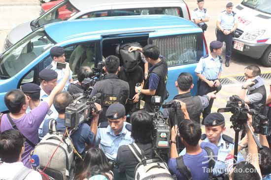 图:绑架案疑犯由探员押解至牛池湾邨对开,开始重组案情本报记者麦国良摄