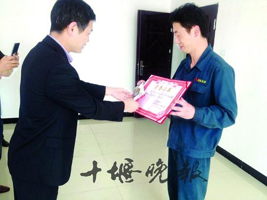 五龙河景区负责人将荣誉证书交到刘平手中