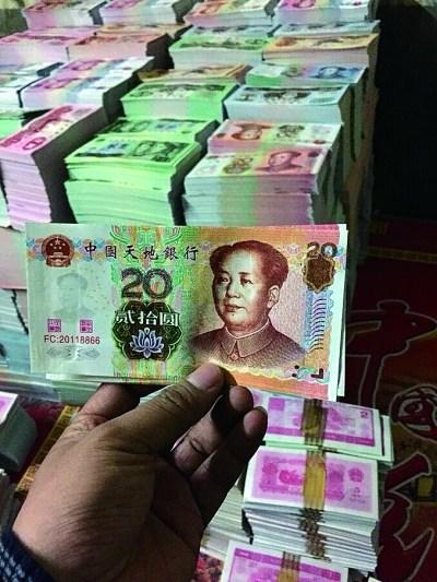 在印刷厂车间内,仿制市面流通的第五版人民币的冥币成堆摆放