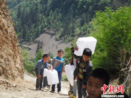 每天长途跋涉取水小学生们。滕树维摄