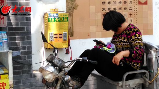 从事短途运输的刘女士正在为电动自行车充电。记者高忠业摄