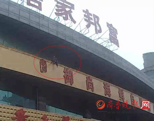 女子跳樓的瞬間,被王學新一把抓住。警方供圖