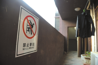 居民所称的事发通道贴有“禁止攀爬”标志,但没有护栏,两侧的门敞开。京华时报记者谭青摄