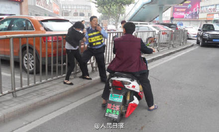 女子违章与交警撕扯 自解衣扣称遭非礼