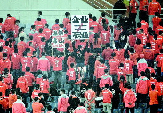 愤怒的鲁能球迷背对球场，以示抗议。本报记者王鸿光摄