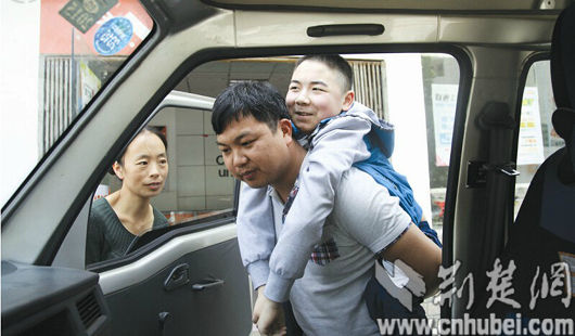 罗红的儿子患肌无力,孙万龙每天都背着90多斤的他上下车。