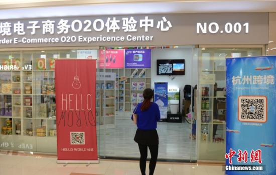 资料图：4月22日，市民在杭州首家跨境贸易O2O体验中心里扫码购物。中新社发 李晨韵 摄