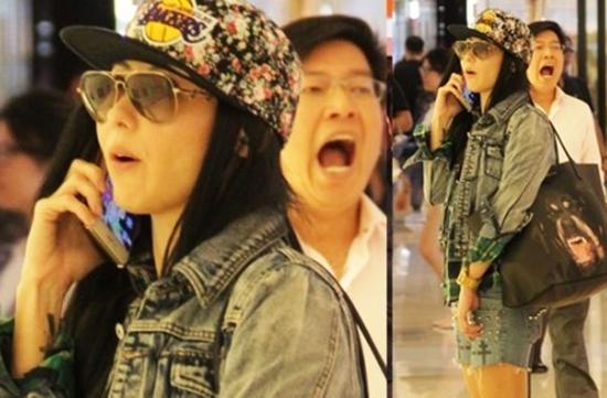 张柏芝反拿手机接电话。