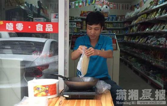 5月13日，长沙，便利店老板符杨每天早晚提供免费手抓饼。图/潇湘晨报记者 朱辉峰