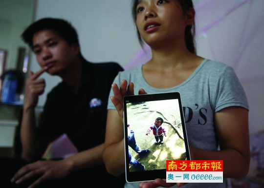 13日,乐乐的妈妈拿着照片,希望能查出儿子死因。南都记者 吴进 摄