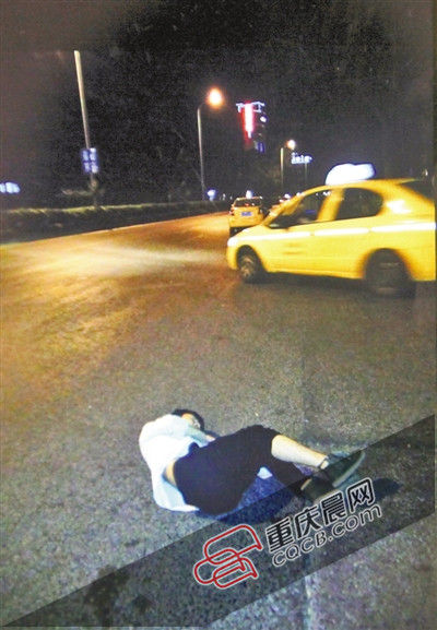江开国保护的男子躺在马路中间不省人事,一动不动。重庆晨报记者 雷键 摄