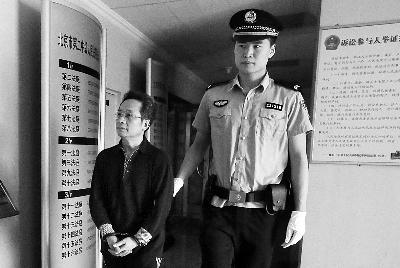 被告人曹建平看见记者面向墙壁躲镜头 /法制晚报记者曹博远