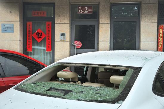 著火樓洞下停放的小轎車被砸，后窗玻璃粉碎