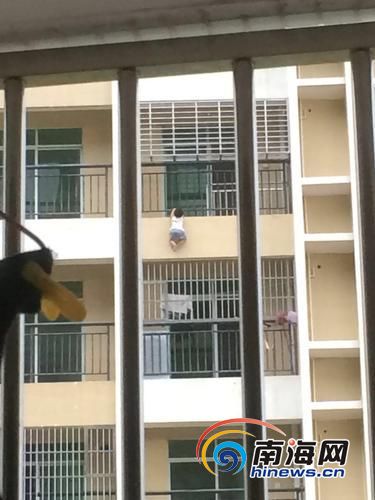 男孩钻出防护栏,悬挂在空中。(市民供图)