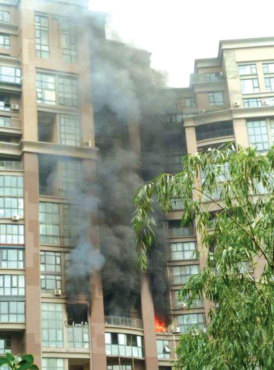 住戶家中起火，濃煙滾滾，樓上墻體均被熏黑