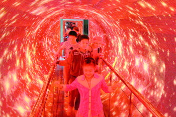 省科技馆免费开放迎来大量市民参观。图为孩子们兴高采烈穿越“时空隧道”。