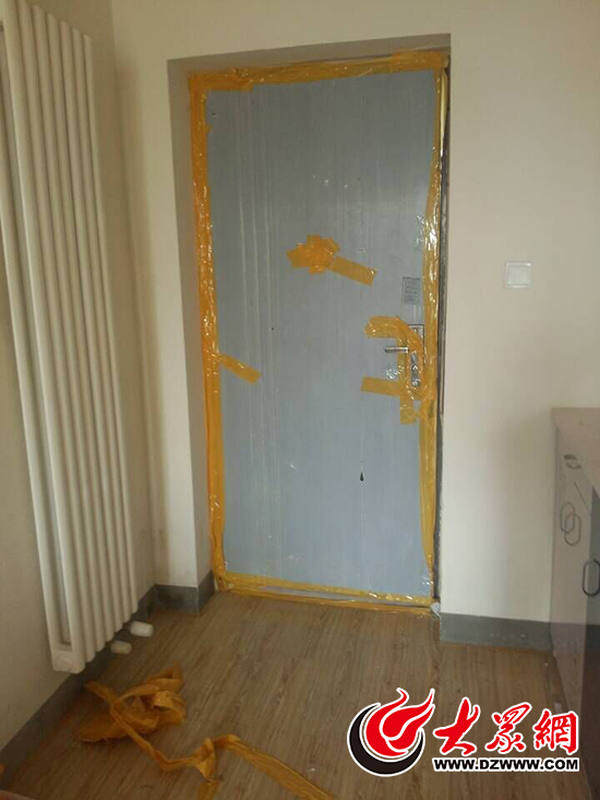 出租屋防盗门内侧全被黄色胶带密封住。