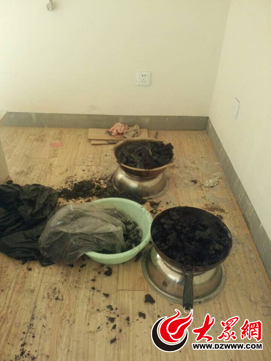 在房间北侧卧室，一个铁锅和一个不锈钢脸盆内盛满了木炭，现在已被水浇灭。