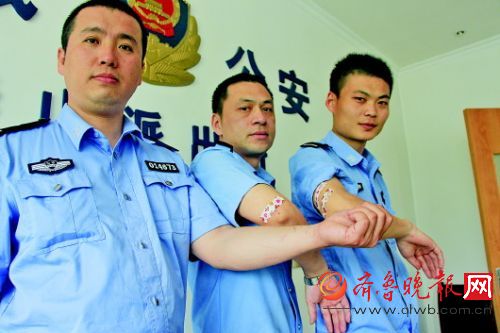 三名參與救人的出警人員手臂都被抓破了。齊魯晚報記者杜洪雷攝