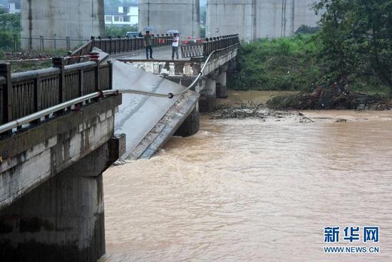 5月22日,广西桂林市恭城瑶族自治县恭城镇孟家村村民在查看被洪水冲断的孟家大桥。新华社记者 周华 摄