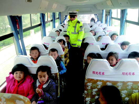 在聊城东阿县,民警在对学生乘坐的校车进行安全检查。