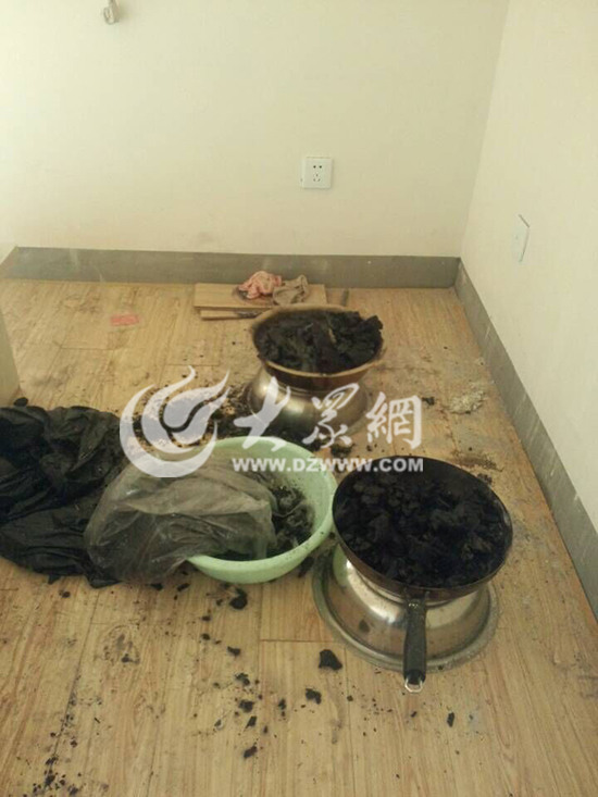 在房间北侧卧室，一个铁锅和一个不锈钢脸盆内盛满了木炭，现在已被水浇灭。