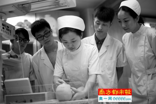 邹芳亮跟几个学弟学妹探讨护理婴儿的做法。