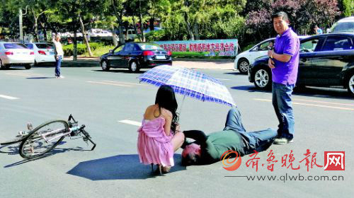 年轻女子为老人打伞遮阳。 齐鲁晚报记者 王震 摄