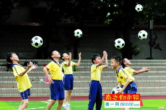 昨日，渔沙坦小学足球队员在抛接球放松身体。南都记者 冯宙锋 摄