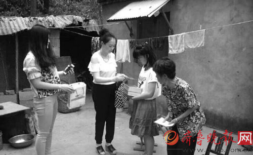 齐鲁晚报枣庄记者站工作人员把捐款和学习用品送到孙慧娟手中。